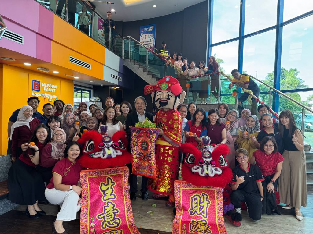 A vibrant lion dance performance taking place at the Nippon Paint Malaysia office to celebrate the Lunar New Year.