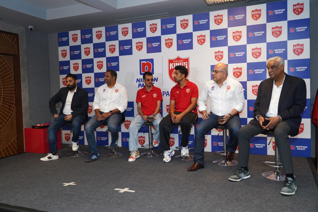 Representatives from Nippon Paint and the Punjab Kings cricket team sitting on stage during a press conference announcing their partnership.