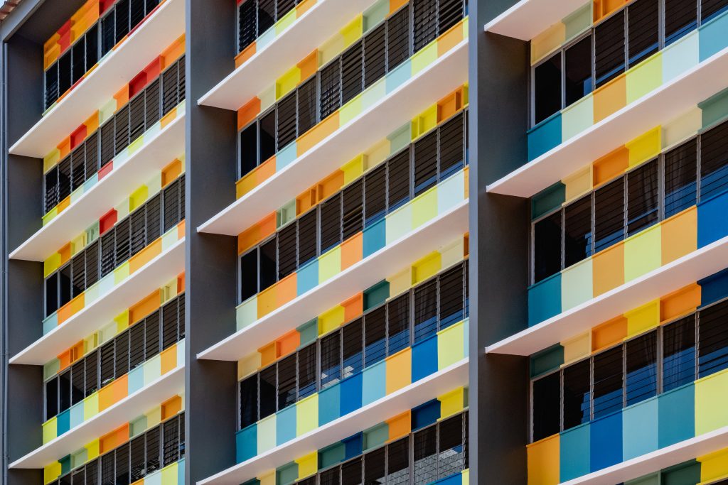 A detailed view of the building's facade, showing the alternating bright colours painted on the window ledges.