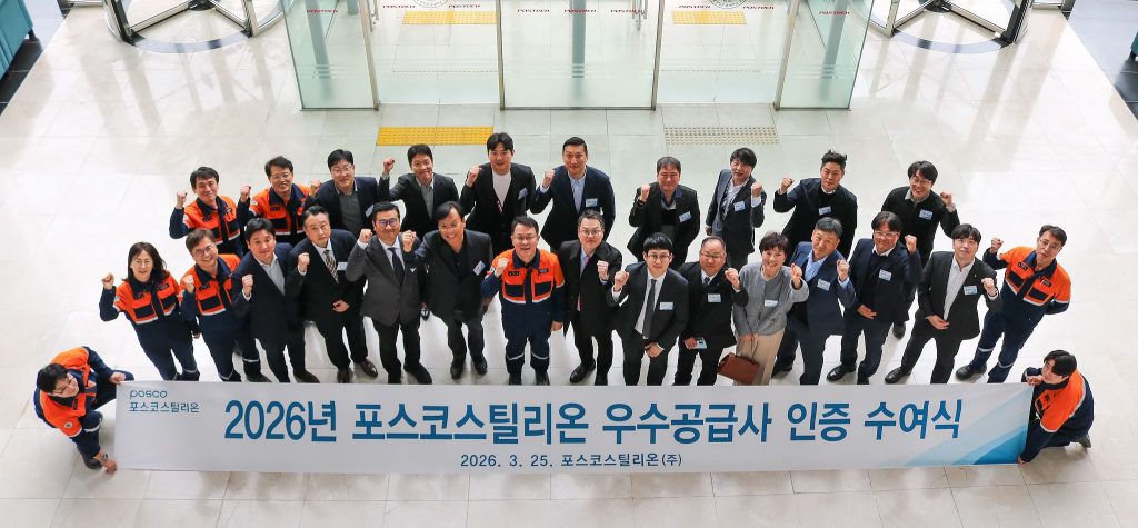 Group photo of NCK and POSCO STEELEON representatives holding a commemorative banner at the certification ceremony.