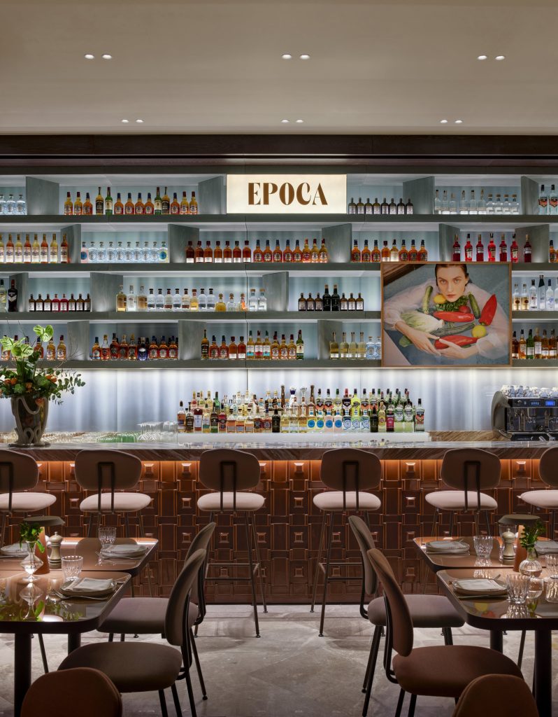 A stylish dining arrangement next to a structural column clad in textured, alternating terracotta tiles.