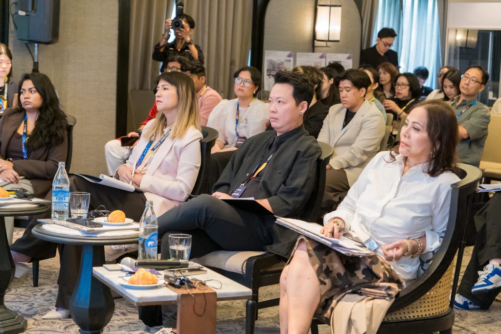 A panel of judges sitting at small round tables, carefully observing a presentation.