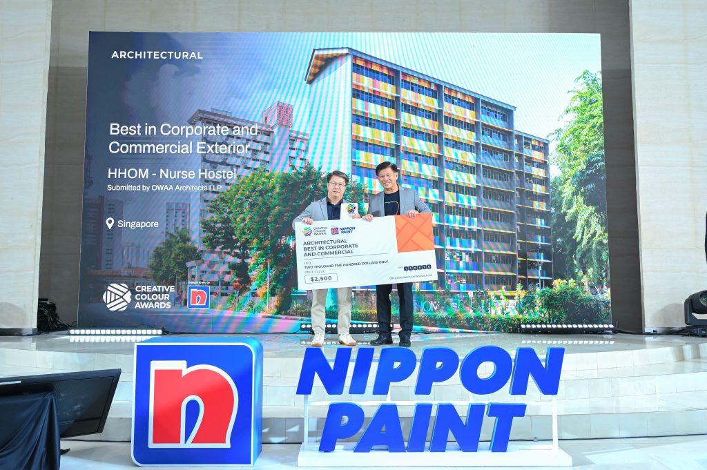 A representative from OWAA Architects receiving the Best in Corporate and Commercial Exterior award cheque on stage from Mr Wee Siew Kim.
