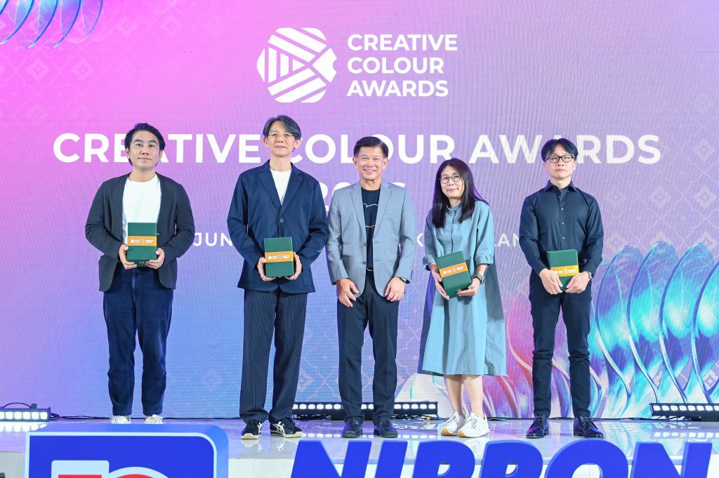The Creative Colour Awards jury members standing on stage receiving tokens of appreciation.