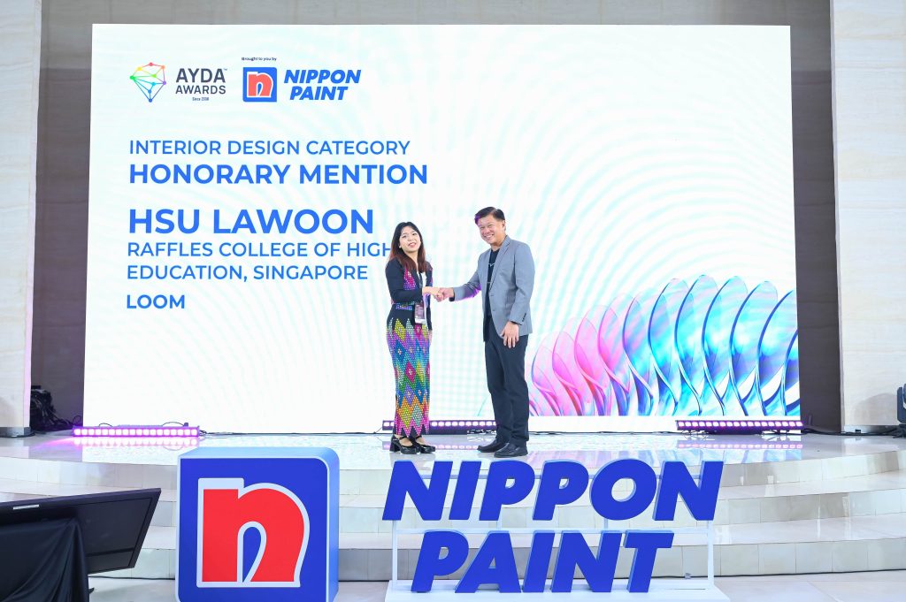 Hsu Lawoon shaking hands with Mr Wee Siew Kim in front of the Honorary Mention screen.