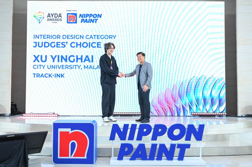 Xu Yinghai shaking hands with Mr Wee Siew Kim in front of the digital awards screen.