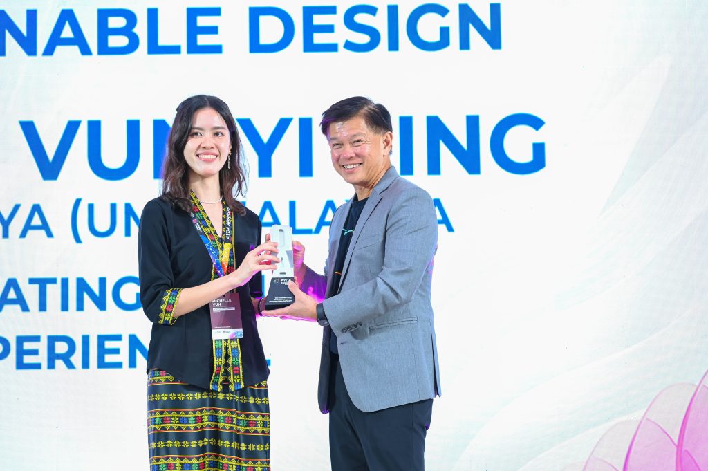 Michelle Vun Yi Ling gracefully receives her sustainable design category trophy from Mr Wee Siew Kim.