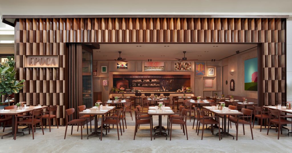The welcoming, open entrance of the Epoca restaurant featuring a highly textured terracotta tiled facade.
