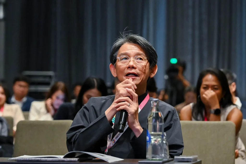 Lai Siew Hong, Chief Executive Designer at Blu Water Studio Sdn Bhd, holding a microphone and speaking thoughtfully from the audience during the Creative Colour Awards.