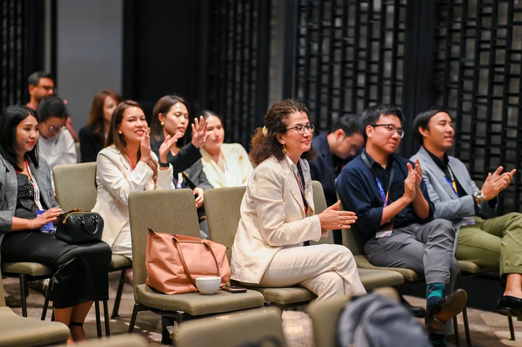A seated audience clapping and smiling warmly during the Creative Colour Awards presentations.