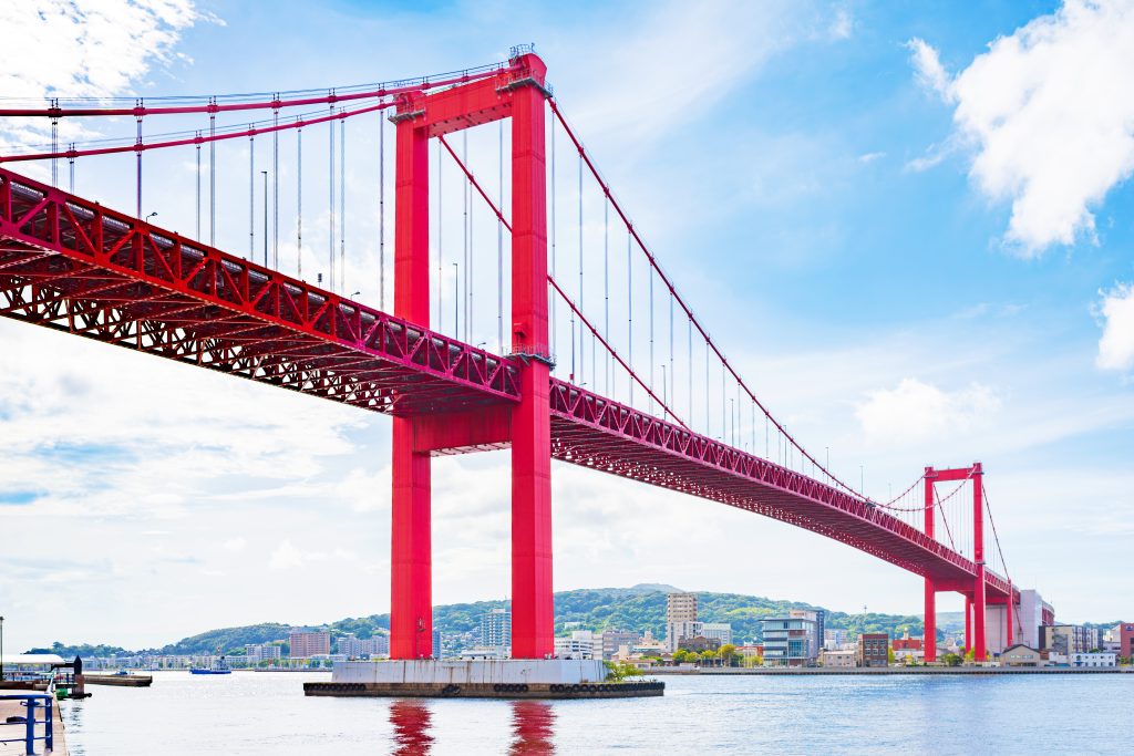 A large red suspension bridge over water, which is protected by the Dangiola coating system.