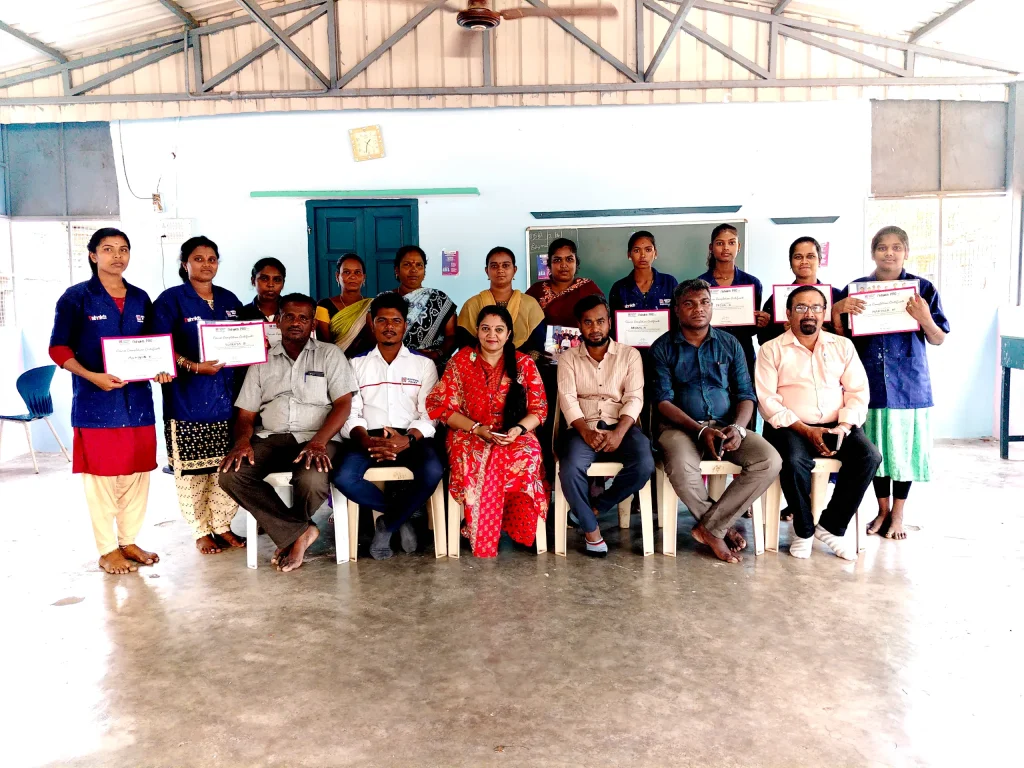 A group of women proudly hold their training certificates alongside program instructors.